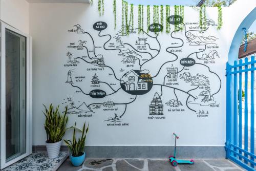 a wall mural of a city with houses at Cô Tư's Homestay in Phan Thiet