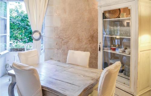 une salle à manger avec une table et des chaises en bois dans l'établissement Cozy Home In Gennes With Kitchen, à Gennes