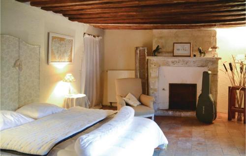una camera con 2 letti e un camino di Cozy Home In Gennes With Kitchen a Gennes