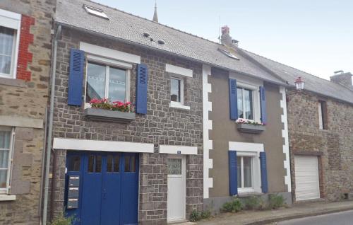 une maison en briques avec portes et fenêtres bleues dans l'établissement Beach Front Apartment, à Saint-Benoît-des-Ondes