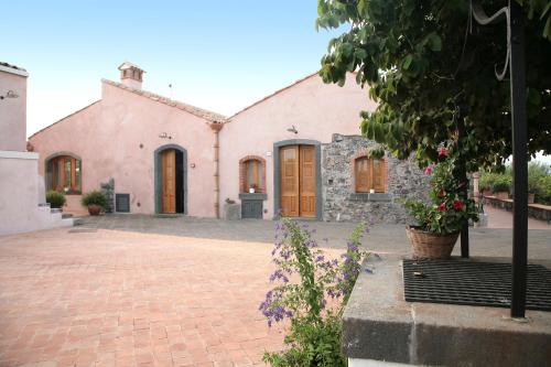 a large pink building with wooden doors at Agriturismo Galea in Riposto