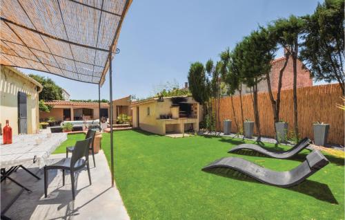 une arrière-cour avec une table et une pelouse verte dans l'établissement 4 Bedroom Awesome Home In Narbonne, à Narbonne