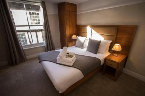 um quarto de hotel com uma cama grande e uma janela em Cathedral Gate em Canterbury