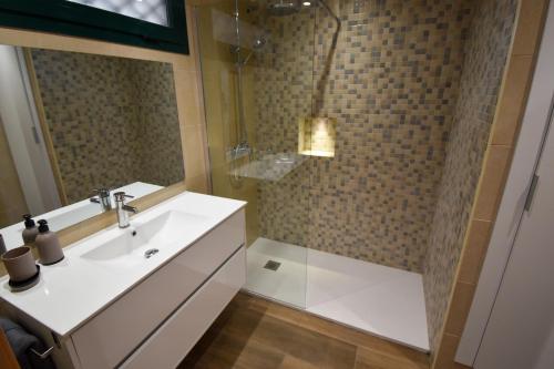 uma casa de banho com um lavatório branco e um chuveiro em Urb Pueblo del Parque, Luxury 2 bedroom apartment. Fantastic central location. em Benalmádena