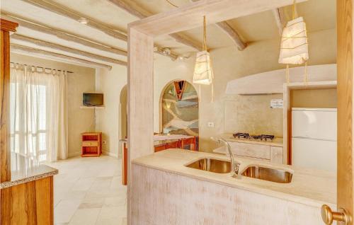 a kitchen with a sink and a refrigerator at Gorgeous Apartment In Golfo Aranci With Kitchenette in Golfo Aranci