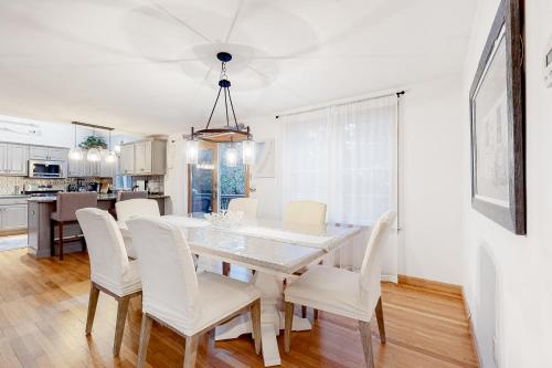 a dining room with a white table and white chairs at Olde Homestead Hideaway in Harwich