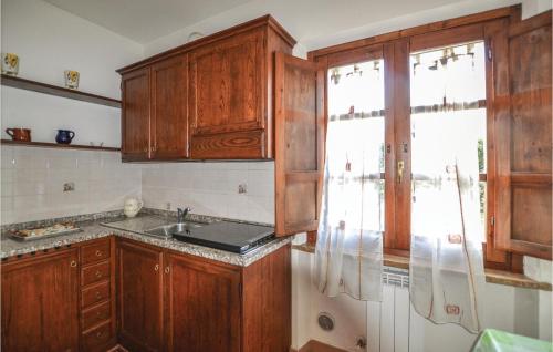 una cucina con armadi in legno, lavandino e finestra di Pesco a Citerna