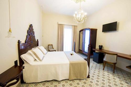 Un dormitorio con una cama grande y una lámpara de araña. en Bolet Casa Modernista, en Castellví de la Marca