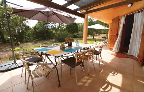 une table avec des chaises et un parasol sur une terrasse dans l'établissement Beautiful Home In Porto Vecchio, à Porto-Vecchio