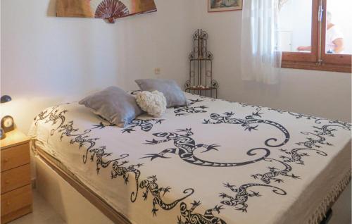 a bed with a black and white comforter on it at Pet Friendly Home In Torrevieja With Kitchen in Torrevieja