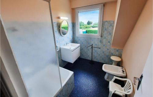 a bathroom with a toilet and a sink and a window at Nice Home In Locoal-mendon With 4 Bedrooms in Kerdavid