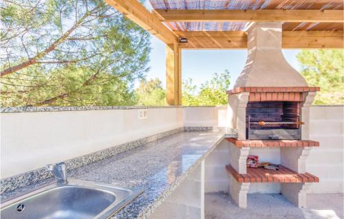 a outdoor kitchen with a pizza oven on the counter at Awesome Home In Iznájar in Iznájar