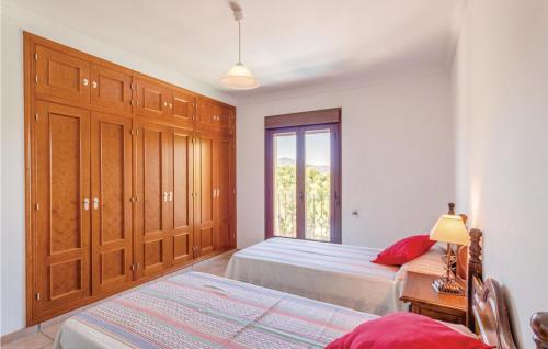 a bedroom with two beds and a window at Awesome Home In Iznájar in Iznájar