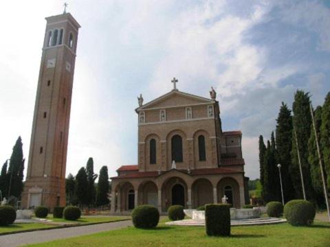 a large building with a clock tower next to a field at Casa Nostra in Selva del Montello
