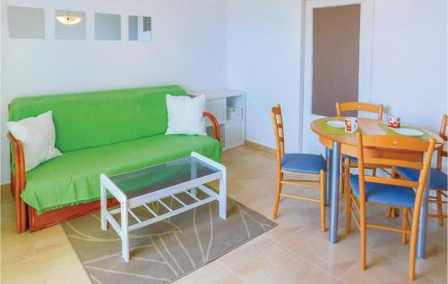 Una sala de estar con un sofá verde y una mesa. en Pet Friendly Apartment, en La Mata