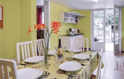 une salle à manger dotée d'une table avec des assiettes et des fleurs. dans l'établissement 2 Bedroom Nice Home In Athis, à Athis