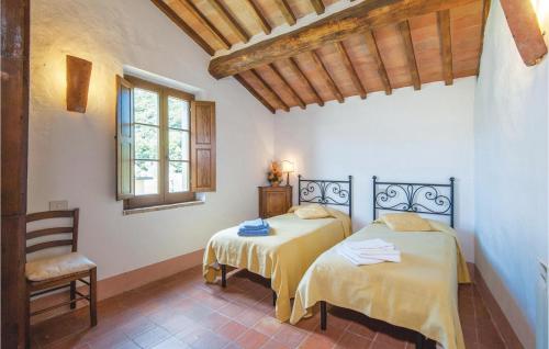 a bedroom with two beds and a chair and a window at Schivanoia 1 in Bagno Vignoni