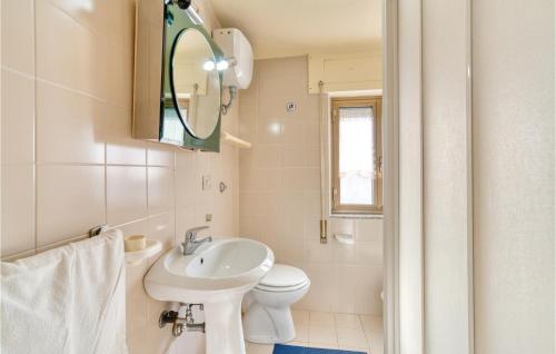 bagno con lavandino, servizi igienici e specchio di Casa Camilla 2 a Cala Gonone