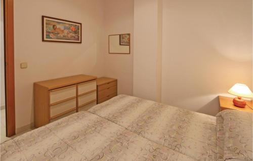 ピネダ・デ・マールにあるAmazing Apartment In Pineda De Mar With 2 Bedrooms And Outdoor Swimming Poolの小さなベッドルーム(ベッド1台、ドレッサー付)