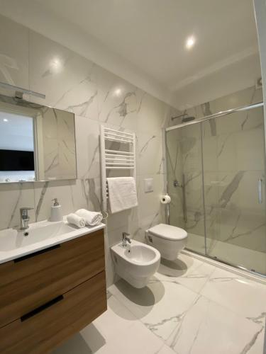 uma casa de banho com um WC, um lavatório e um chuveiro em Barium Suite - Elegante Appartamento in Centro em Bari