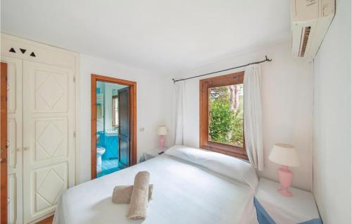 a bedroom with a white bed and a window at Bellavista in Porto Rotondo