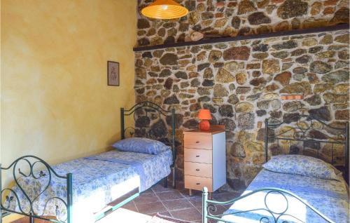 a bedroom with two beds and a stone wall at Stunning Home In Palmi With Wifi in Palmi