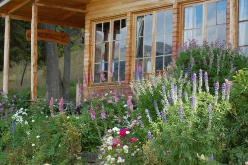 a garden of flowers in front of a house at Mallin Colorado Ecolodge in Aldana