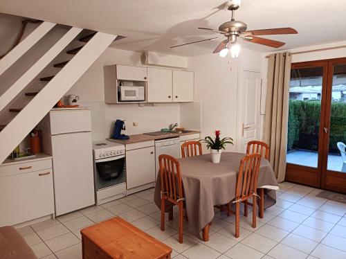 eine Küche mit Tisch und ein Esszimmer in der Unterkunft Maison charmante à Vias + Piscine partagée in Vias