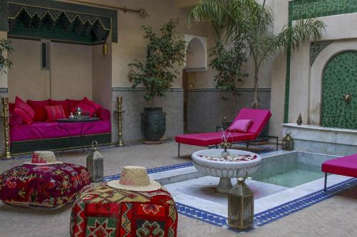 a living room with pink furniture and a fountain at Riad Dar Habiba by Garden Wonders in Marrakech