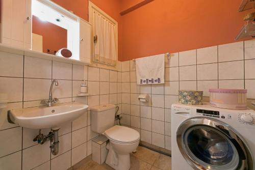 a bathroom with a washing machine and a washer at Corfu Garitsa Spacious Apartment in Corfu