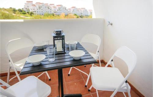 einen schwarzen Tisch und weiße Stühle auf dem Balkon in der Unterkunft 2 Bedroom Lovely Apartment In Estepona in Estepona