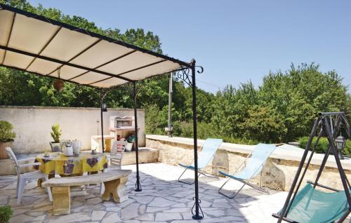 Un patio con una mesa y sillas bajo una sombrilla. en Amazing Home In Ladornac With Kitchen, en La Dornac