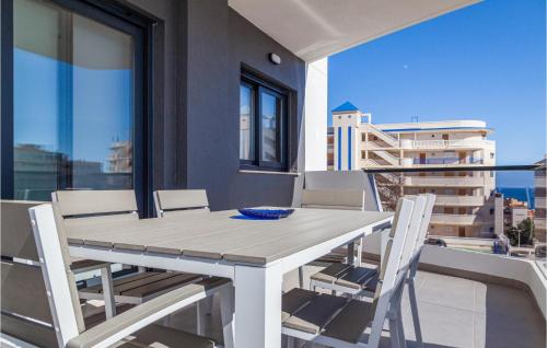 einen weißen Esstisch und Stühle auf dem Balkon in der Unterkunft Nice Apartment In Los Arenales Del Sol in Arenales del Sol