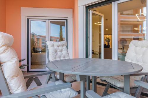 a table and chairs in a room with a window at Deluxe 2BDR Apartment in Carcavelos by LovelyStay in Carcavelos