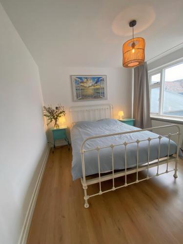 een slaapkamer met een bed en een groot raam bij Fijn guesthouse in Noordwijk