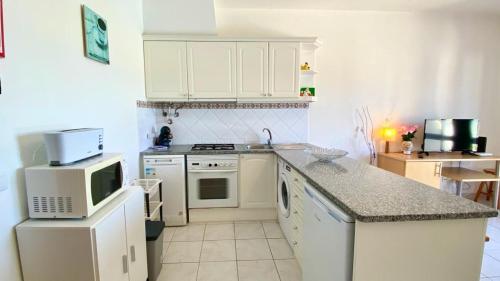 a kitchen with white appliances and a counter top at Casa de Campo LAGOA DOS SALGADOS in Pêra