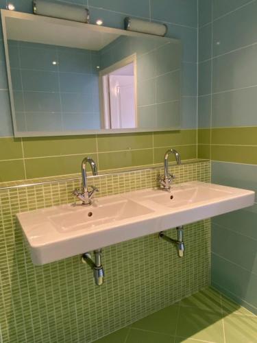 een badkamer met 2 wastafels en een spiegel bij Fijn guesthouse in Noordwijk