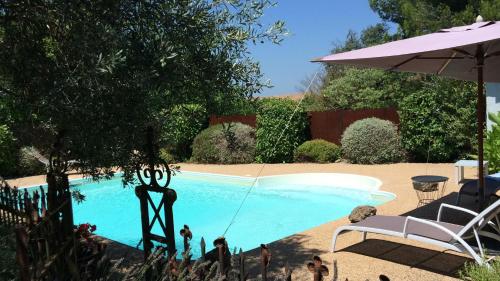 una piscina con columpio y sombrilla en La Douce France en Les Taillades