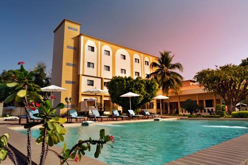 un hôtel avec une piscine en face d'un bâtiment dans l'établissement Dunia Hotel Bamako, à Bamako