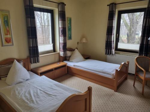 Postel nebo postele na pokoji v ubytování Altes Teichhaus - Pension Ottendorf-Okrilla