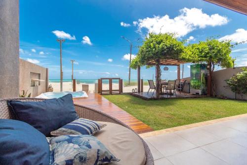 a couch on a patio with a view of the beach at Casa ao mar da Praia de Pirangi por Carpediem in Parnamirim