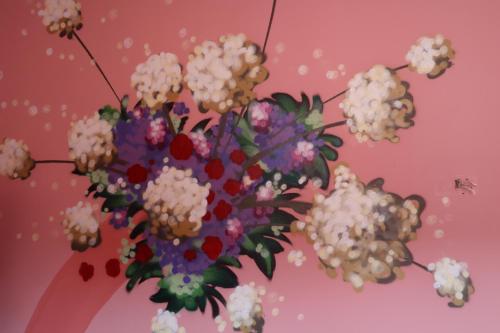 a vase filled with white flowers on a pink background at Muraless Art Hotel - WorldHotels Crafted in Castel d'Azzano