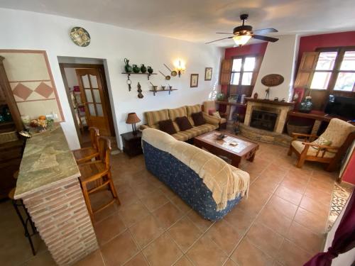 een woonkamer met een bank en een open haard bij Casa el saladillo in Valle de Abdalagís