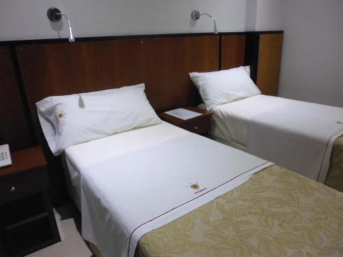 two beds sitting next to each other in a room at Hotel Athos in Buenos Aires