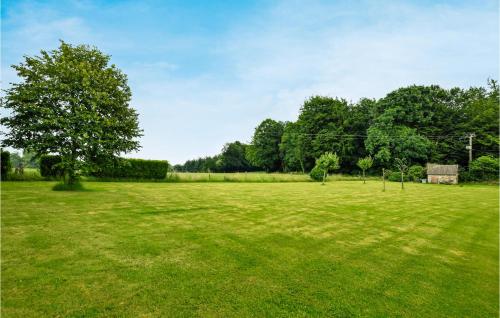 a large grass field with a tree in the middle at Stunning Home In Saint-Sever-Calvados in Saint-Sever-Calvados