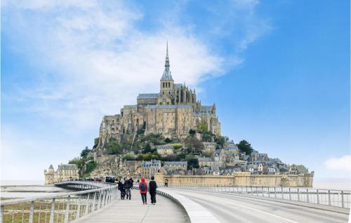 a group of people walking on a bridge in front of a castle at Stunning Home In Saint-Sever-Calvados in Saint-Sever-Calvados