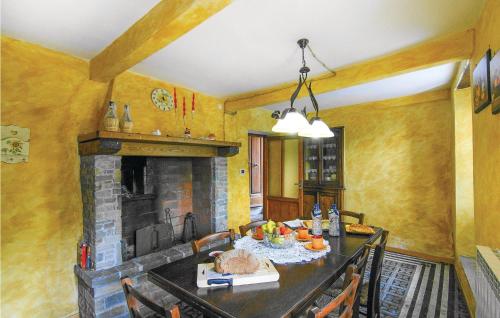 a dining room with a table and a fireplace at Awesome Home In Montefegatesi With Wifi in Tereglio