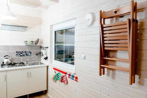 uma cozinha com paredes brancas, um lavatório e uma janela em Camping Pomona em Niechorze