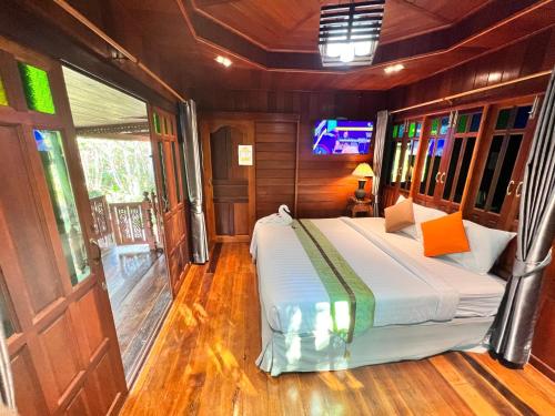 a bedroom with a bed in the middle of a room at บ้านสวนในฝัน-ตลาดน้ำท่าคา in Samut Songkhram