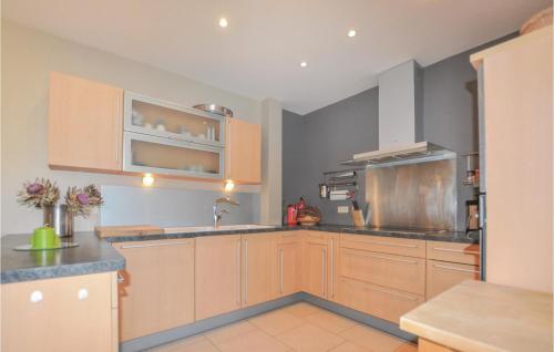 une cuisine avec des armoires en bois et un évier dans l'établissement Cozy Home In Villelongue, à Villelongue-de-la-Salanque